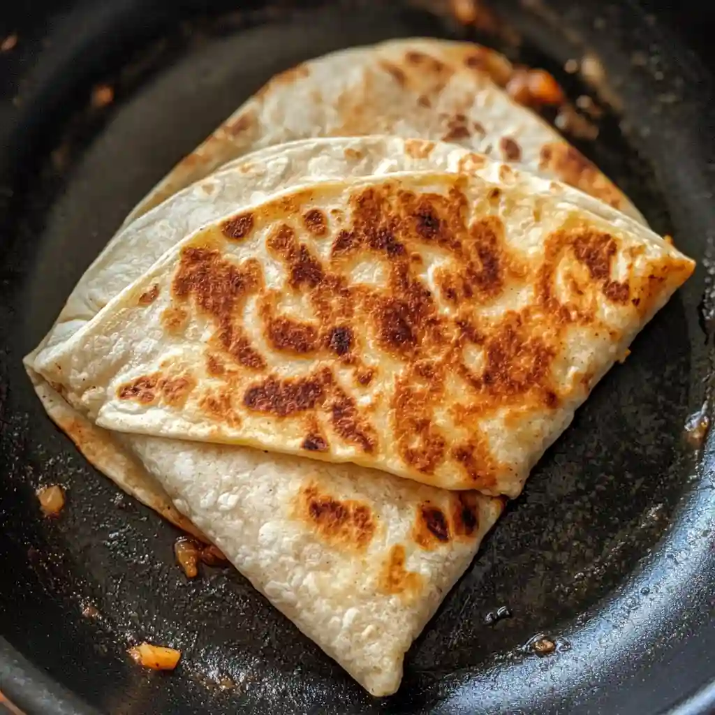 Cheez It Crunchwrap grilling in a skillet